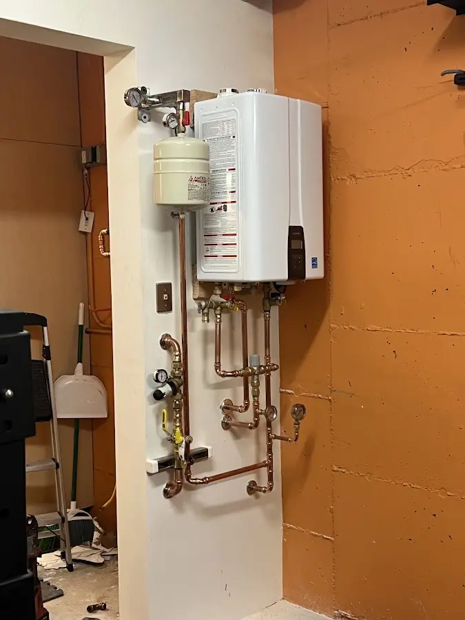 Plumbing technician inspecting water heater connections in Grangeville